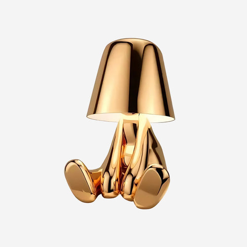 Bordslampa med fot i form av en sittande figur – spegelblank yta