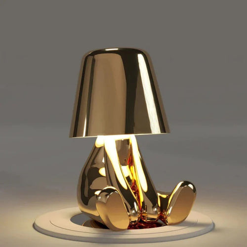 Bordslampa med fot i form av en sittande figur – spegelblank yta