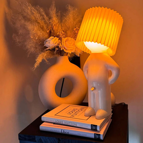 Bordslampa med fot i form av en stående figur – veckad lampskärm
