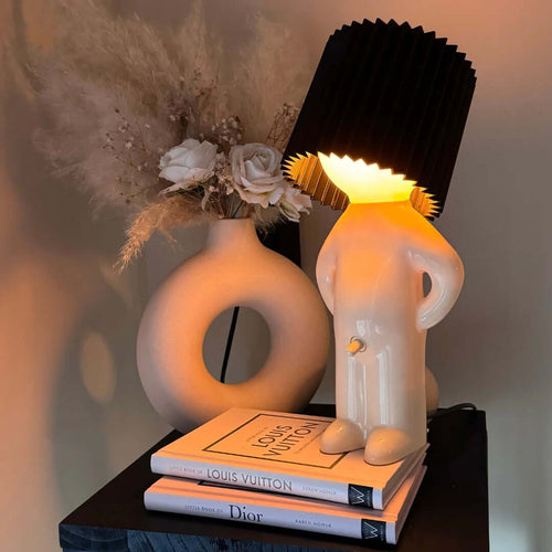 Bordslampa med fot i form av en stående figur – veckad lampskärm