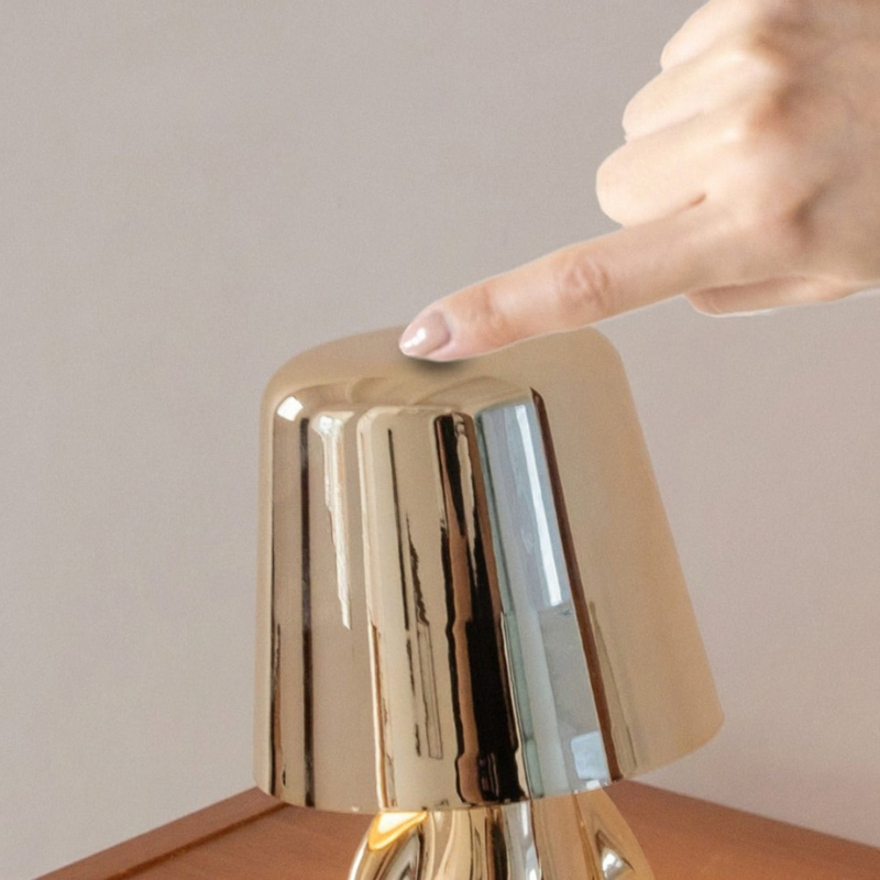 Bordslampa med fot i form av en sittande figur - spegelblank yta